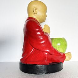 Statue de moine et son bol à obole en prière sous un mandala du Népal